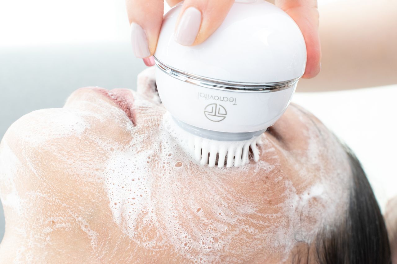 services-02 Womans face being cleaned with an electric cleansing brush and foam.